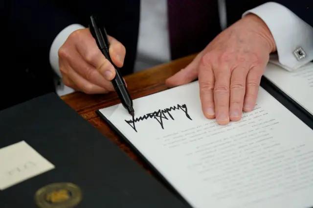 Donald Trump firmando una orden ejecutiva en el Despacho Oval de la Casa Blanca, en Washington, Estados Unidos, en su primer día como presidente, el 20 de enero de 2025.